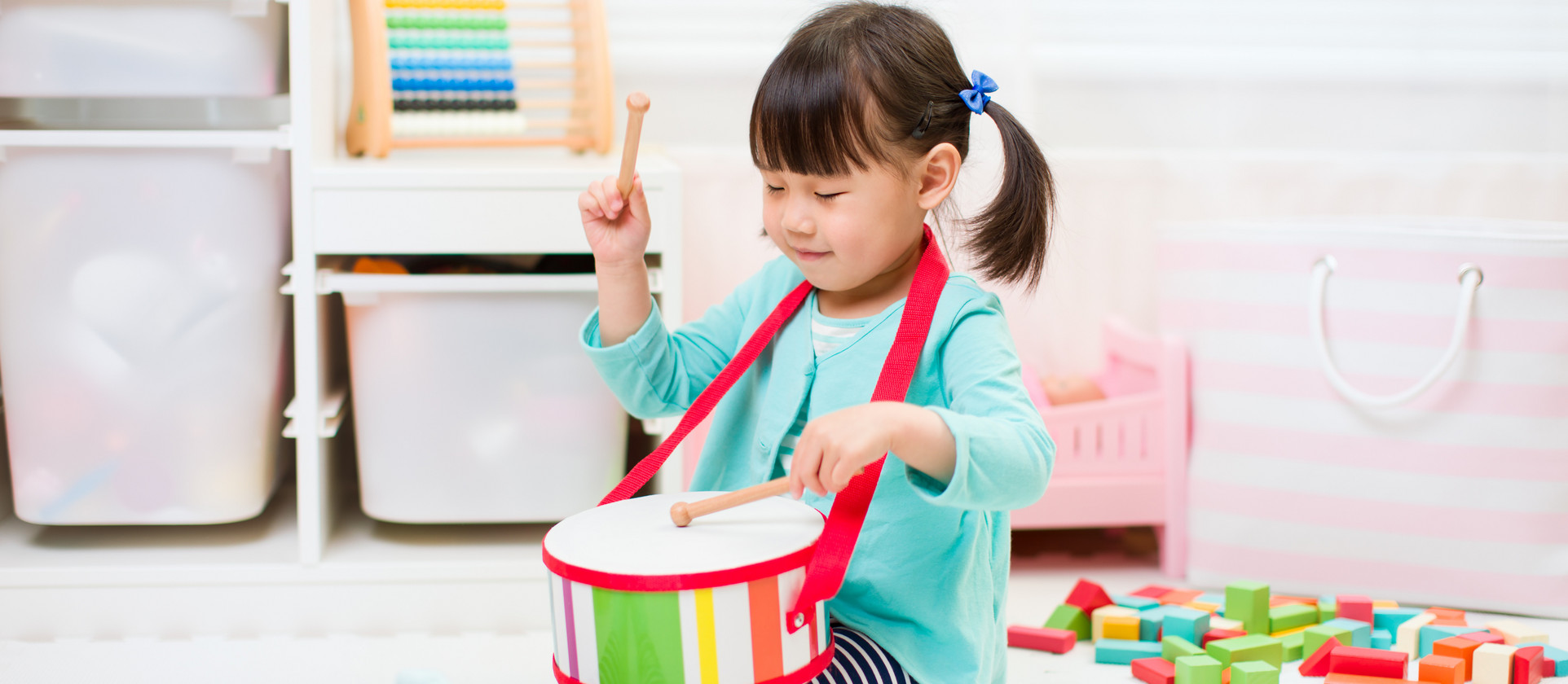 toddler girl play drum at home for homeschooling