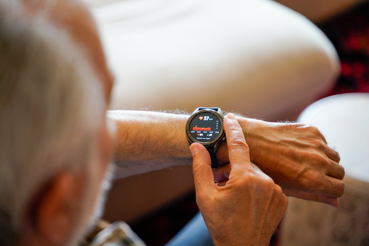 old white haired man using smart watch checking his cardiogram e