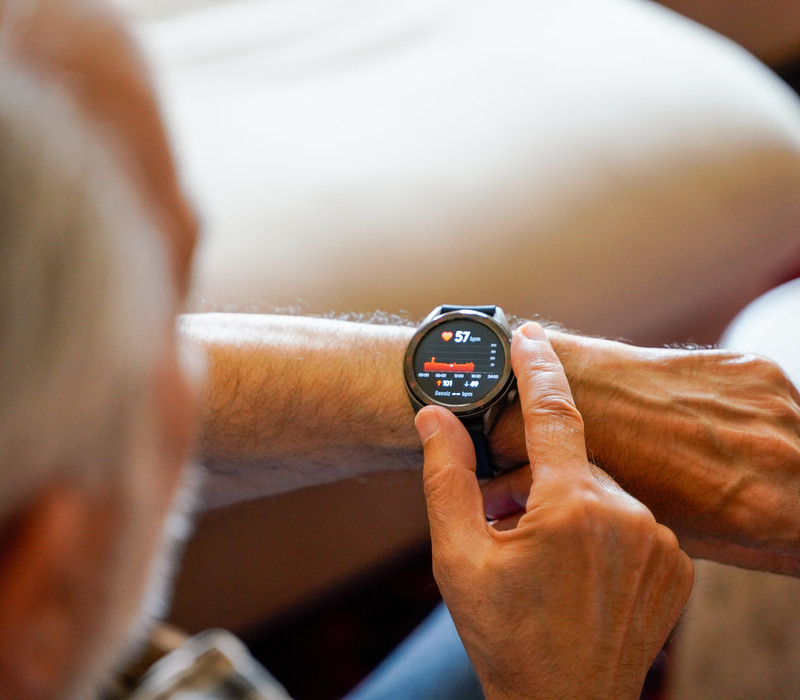 old white haired man using smart watch checking his cardiogram e